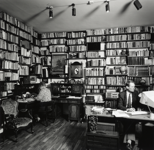 108269 Interieur van een huis aan de Bolstraat te Utrecht: studeerkamer, met de bewoners van het huis.